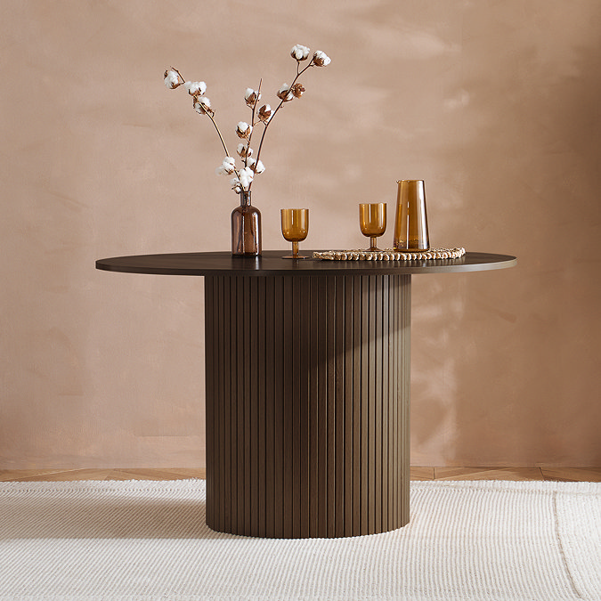 image of round walnut brown fluted dining table without chairs