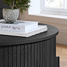 close up image of black wood surface of round fluted coffee table