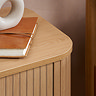 close up on corner of oak bedside table, smooth top and fluted body