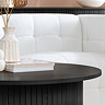 close up on smooth black top of wooden coffee table in front of white sofa, and topped with decorative vases