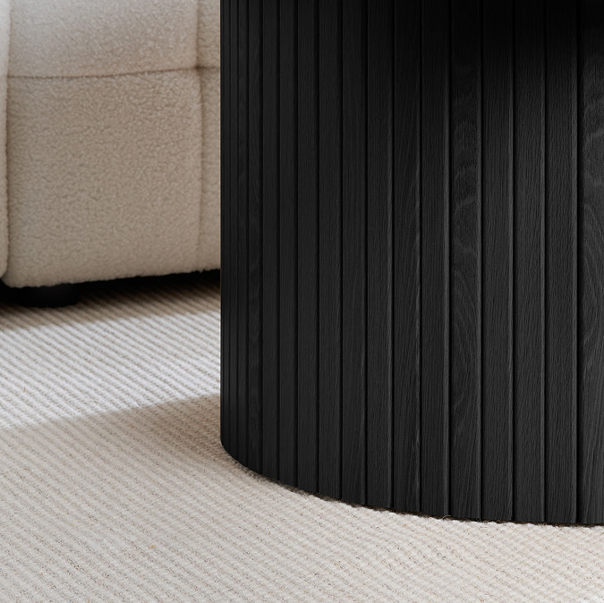 close up image of fluted lower half of black wooden coffee table
