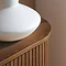close up image of corner of walnut sidetable, smooth wood finish and fluted body