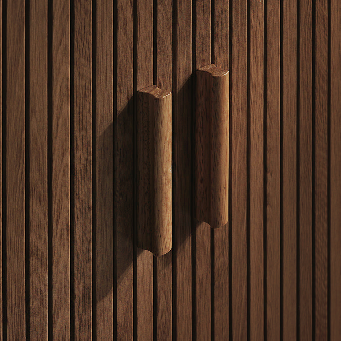 close up on wooden handles of closed walnut drawers with fluted detail