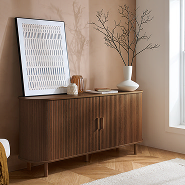image of walnut coloured fluted sideboard with doors open to reveal four shelving spaces inside, filled with plates and other crockery.