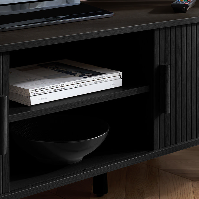 close up image on middle shelf of black wood effect tv unit