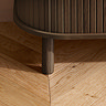 close up on walnut coloured wood legs of tv stand, on light wood floor