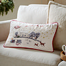 rectangular christmas cushion, cream with winter scene, sat on cream sofa
