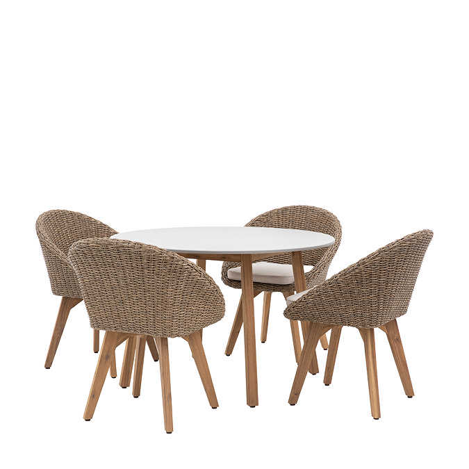 image cut out on white background of wicker dining set: seats with curved back and plush cushion, tucked into a round table with acacia wood legs