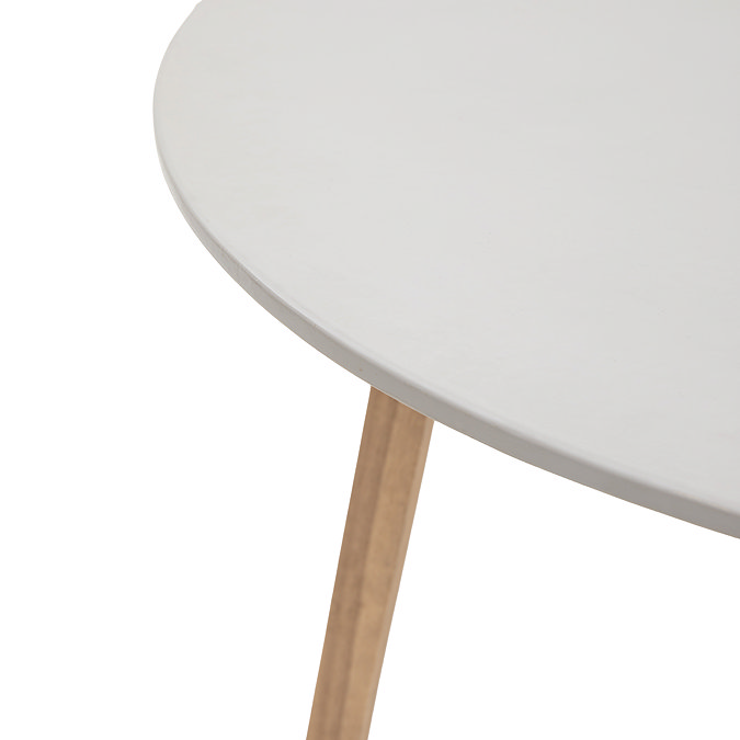 close up image of smooth white seat and acacia wood legs of outdoor table