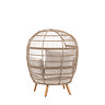 cut out image taken from the back of rounded wicker garden egg chair with light wood legs and cream cushions