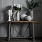 image of grey planter and matching tall vase on a side table in front of a dark grey panelled wall