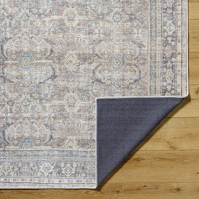 close up image of vintage rug with brown and blue shades, corner folded up to show material underneath