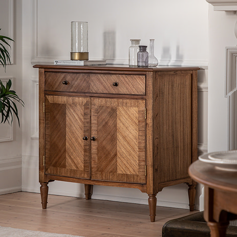image of mindi wood sideboard with 2 doors and 1 drawer, against a cream wall and topped with decorative accessories