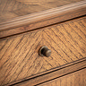 close up image of wooden finish of sideboard drawer with small beehive pull handle