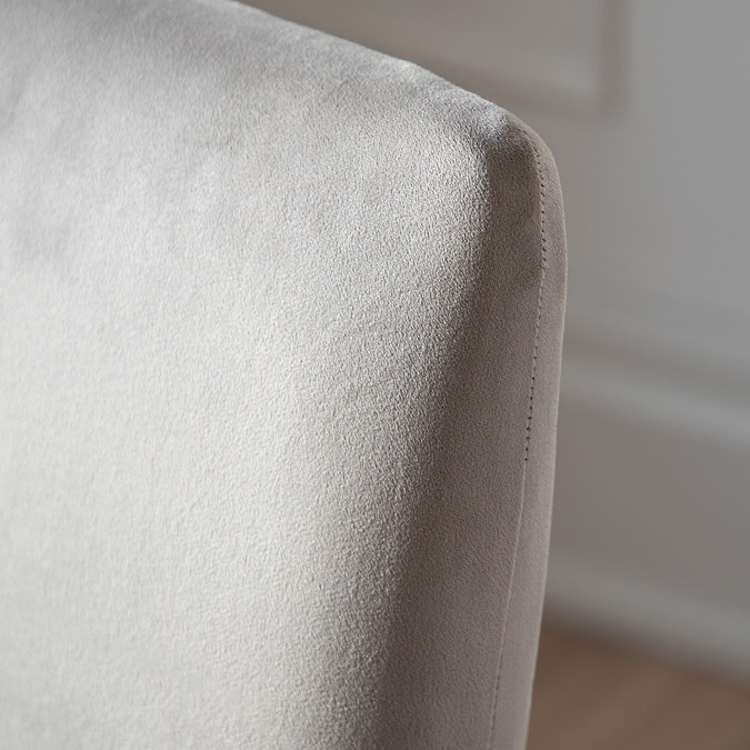 close up image of upholstered grey velvet material on seat of dining chair