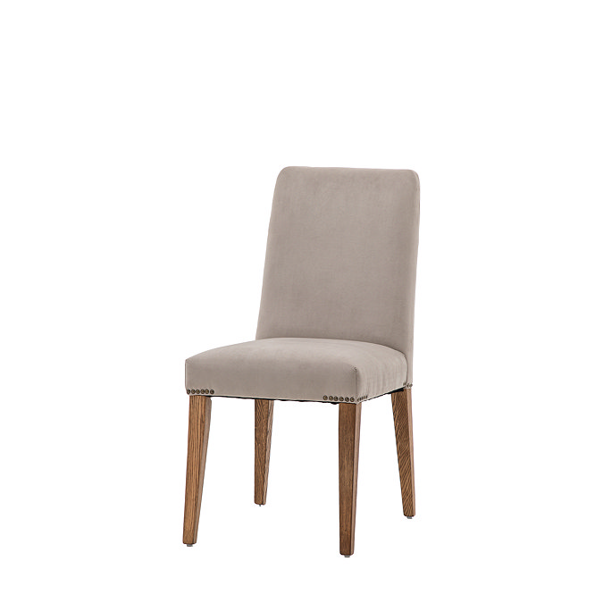 image cut out on white background of dove grey velvet upholstered dining chair with mindi wood legs