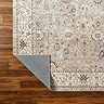 close up image of brown vintage floral rug with corner folded over to show material underneath