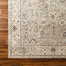close up swatch image of brown floral vintage rug on dark wood flooring, focus on colour and texture