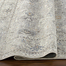 close up image of grey floral vintage rug folded up to suggest its thinness