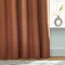 Close up of bottom of dark orange curtains touching the floor.