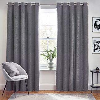 Charcoal grey curtains open in front of living room window.
