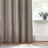 Close up of light grey curtains brushing wooden floor.