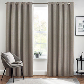 Floor length light grey curtains in front of window