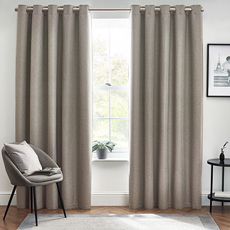 Floor length light grey curtains in front of window