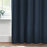 Close up of dark blue curtains brushing the floor