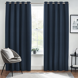 Midnight blue floor length curtains open in front of a window