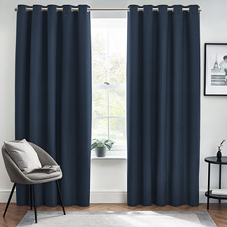 Midnight blue floor length curtains open in front of a window