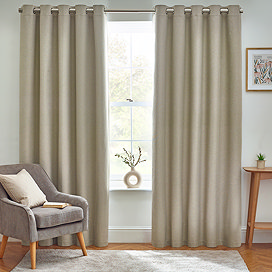 Floor length natural coloured curtains open in front of window