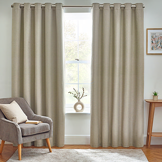 Floor length natural coloured curtains open in front of window