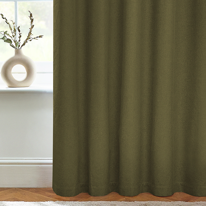 Close up of olive green curtains brushing the floor