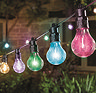 close up image of multi coloured festoon string lights outside house at night