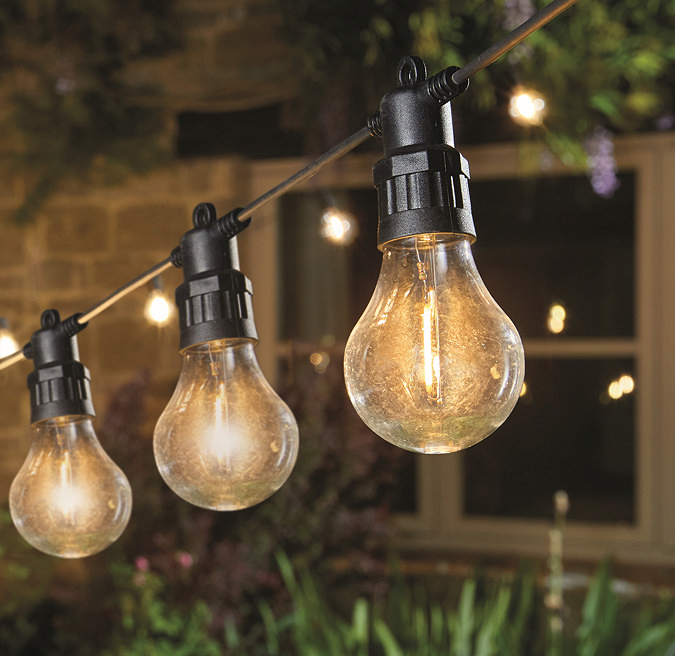 close up image of warm white classic string light bulbs glowing at night