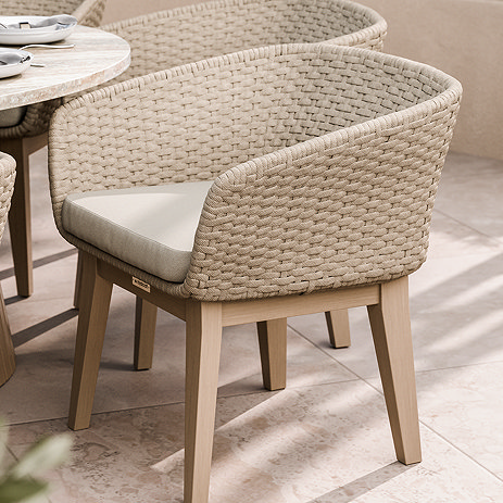 image of natural rope weave curved garden dining chair on stone patio