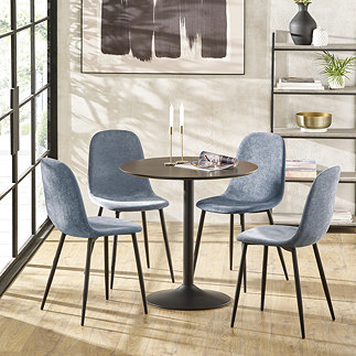 image of four denim blue chenille dining chairs with black metal legs round a black metal table on wooden flooring