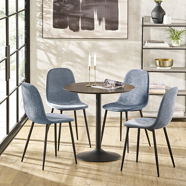 image of denim blue dining room chair tucked in next to black round table