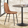 image of orange chenille dining chair with black metal legs tucked next to back metal round dining table