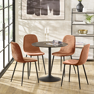 image of four orange chenille dining chairs with black legs tucked under round black metal dining table, on light wooden flooring in front of floor length room