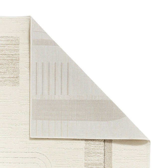 image of cream abstract rug with beige curved pattern, corner folded over to show floor-facing material