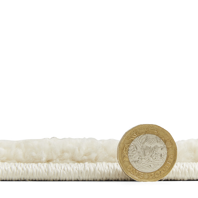 image of rug lying flat with pound coin stood up next to it, to show rug as two thirds of the height of the coin