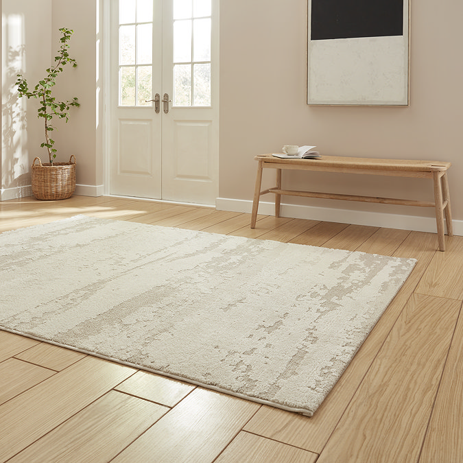angled image of cream contemporary abstract rug on wooden floor