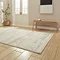 angled image of cream contemporary abstract rug on wooden floor