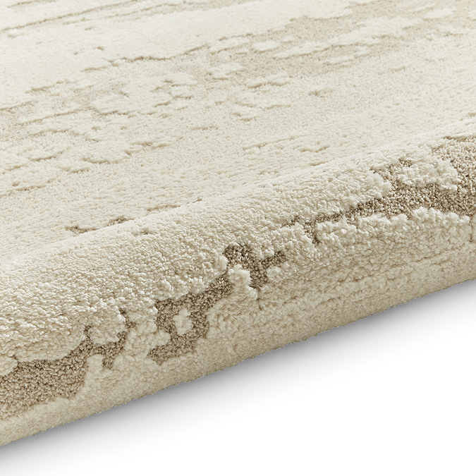 image of marble effect textured cream rug rolled up at end