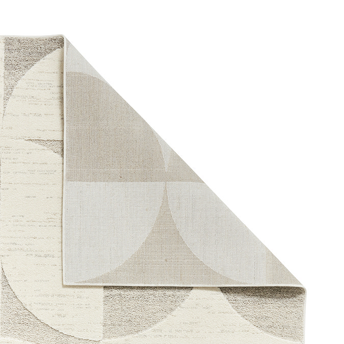 geometric cream and beige rug folded over in corner to show floor-facing material