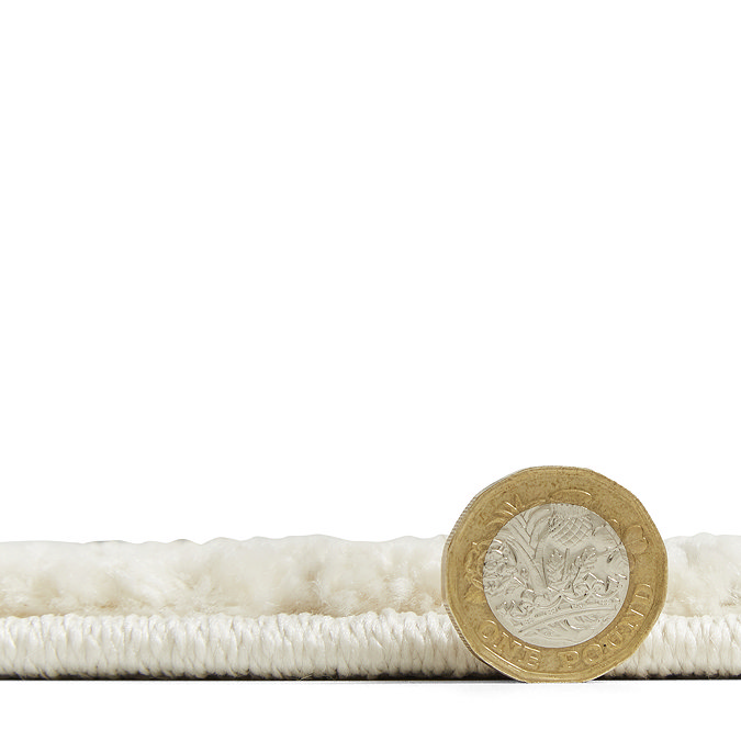 rug laid flat with pound coin stood up beside it to show rug as half coin's height