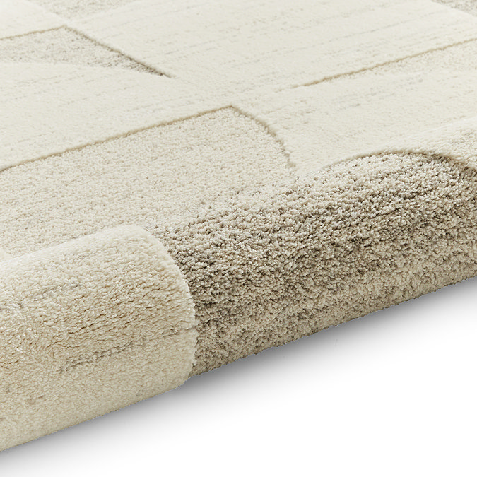 image of beige and cream geometric rug rolled up at the end