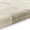 image of beige and cream geometric rug rolled up at the end